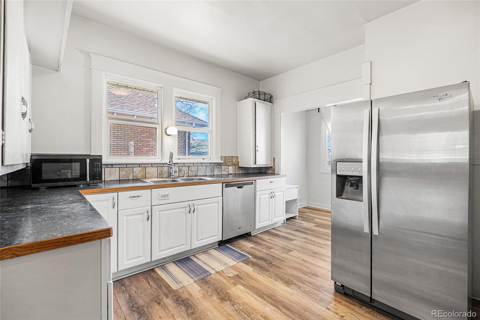 1117 16th Street Greeley, CO 80631 - Photo 10 of 37 a large kitchen with granite countertop a refrigerator and a sink