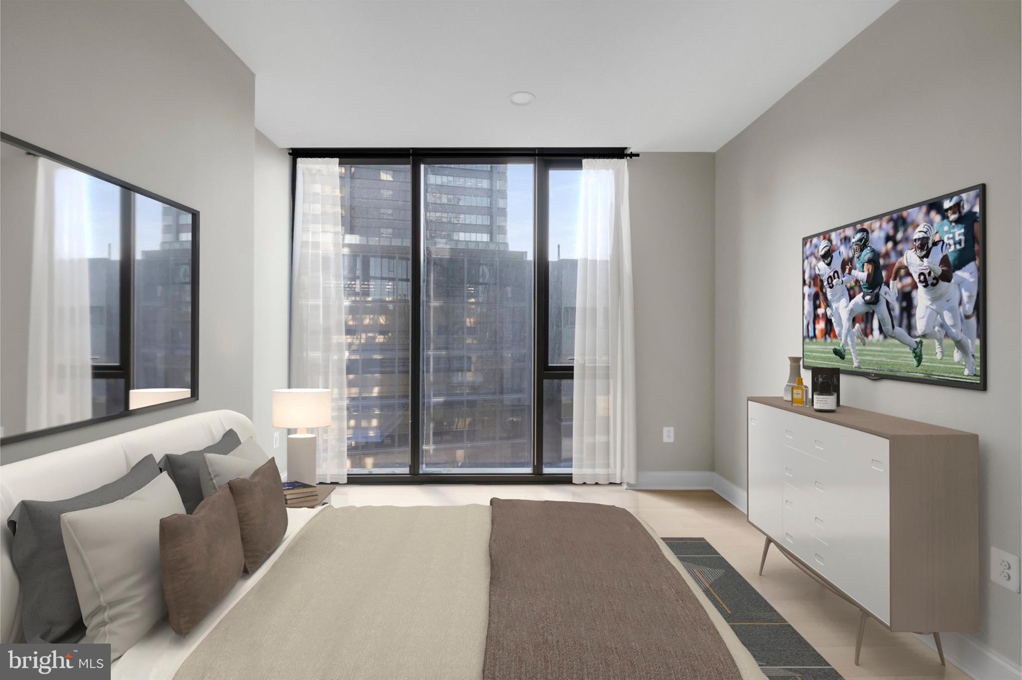 2301-61 John F Kennedy Boulevard, Unit 1815 Philadelphia, PA 19103 - Photo 27 of 39 a spacious bedroom with a large bed and a couch