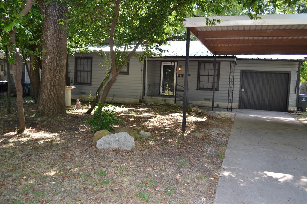 Front view of the home featuring a shaded yard and private entrance.
