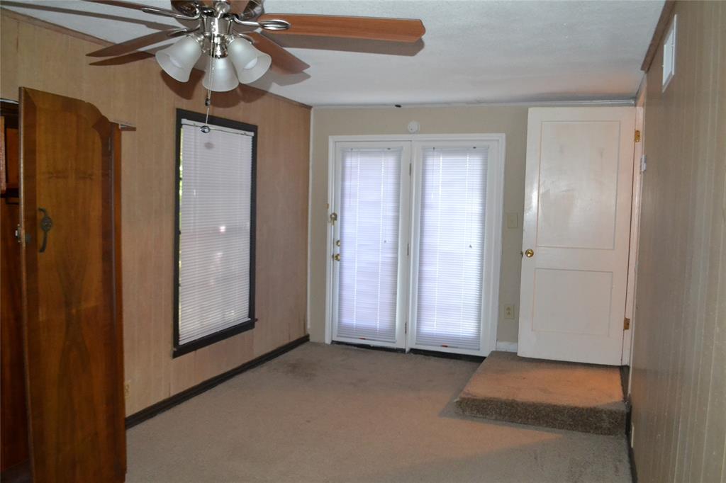 919 Denton Street Denton, TX 76201 - Photo 12 of 23 Large bedroom with a ceiling fan and a door leading outside.