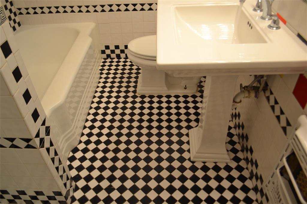 919 Denton Street Denton, TX 76201 - Photo 18 of 23 Full bathroom view showing the pedestal sink and checkered tile.