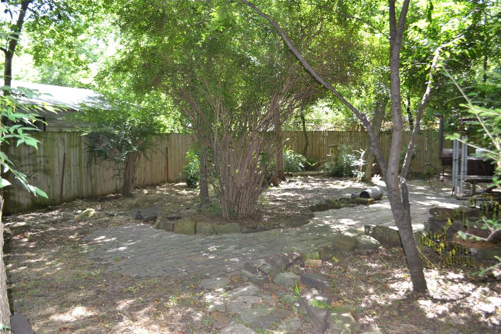 919 Denton Street Denton, TX 76201 - Photo 22 of 23 Shaded backyard path surrounded by trees.