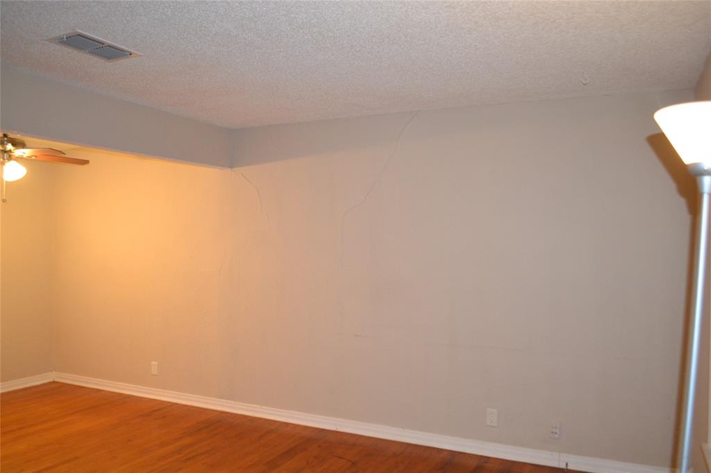 919 Denton Street Denton, TX 76201 - Photo 3 of 23 Spacious living room with fresh paint and warm hardwood flooring