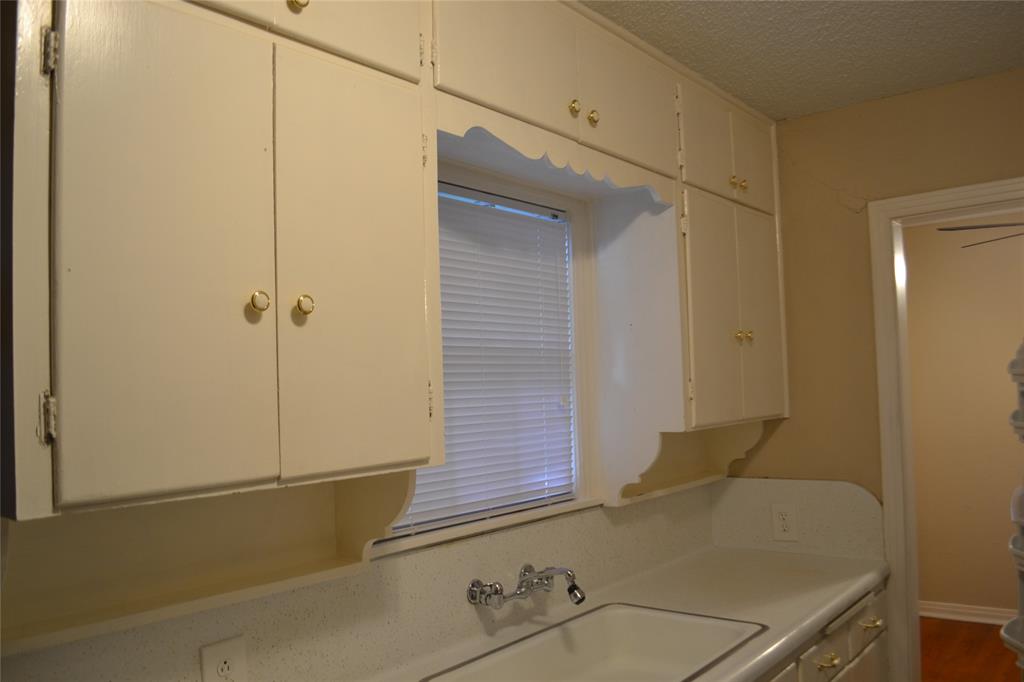 919 Denton Street Denton, TX 76201 - Photo 6 of 23 Functional kitchen area with ample cabinet storage and a window.