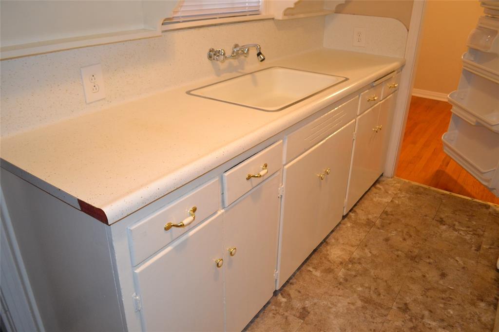 919 Denton Street Denton, TX 76201 - Photo 8 of 23 Clean kitchen workspace with a double sink and white cabinetry.