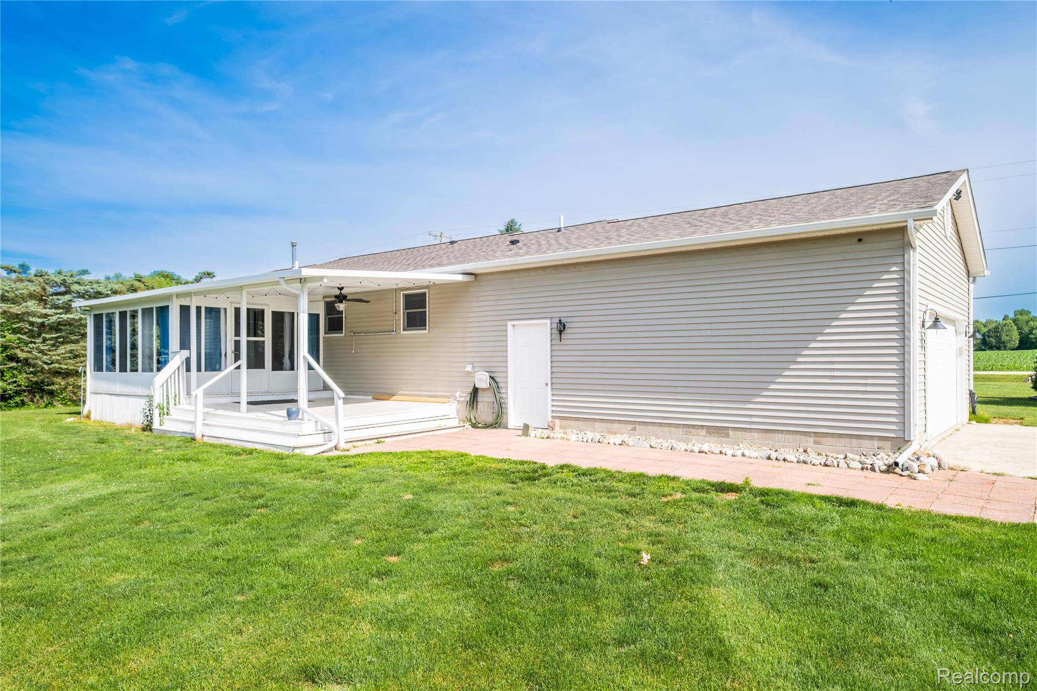 9600 Hamill Road Otisville, MI 48463 - Photo 28 of 32 Rear exterior featuring a sunroom addition, an open-air deck, and an attached two-car garage
