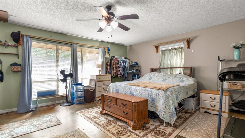 19036 Northwest 246th Street High Springs, FL 32643 - Photo 17 of 30 a bedroom with a bed and a chandelier