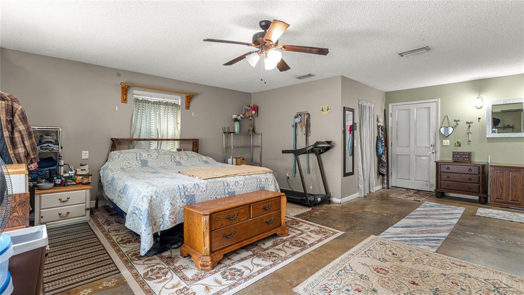 19036 Northwest 246th Street High Springs, FL 32643 - Photo 18 of 30 a bedroom with bed and a chandelier