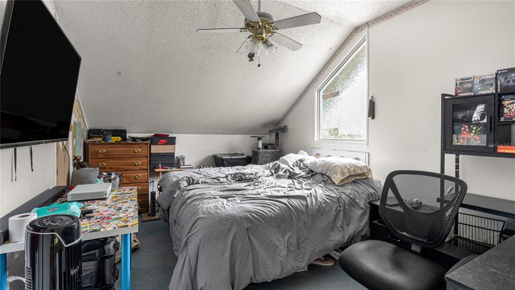 19036 Northwest 246th Street High Springs, FL 32643 - Photo 21 of 30 a bed sitting in a bedroom next to a window with pc on the table