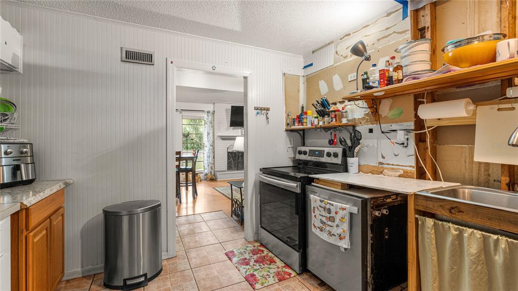 19036 Northwest 246th Street High Springs, FL 32643 - Photo 9 of 30 a kitchen with stainless steel appliances granite countertop a stove a sink and a refrigerator
