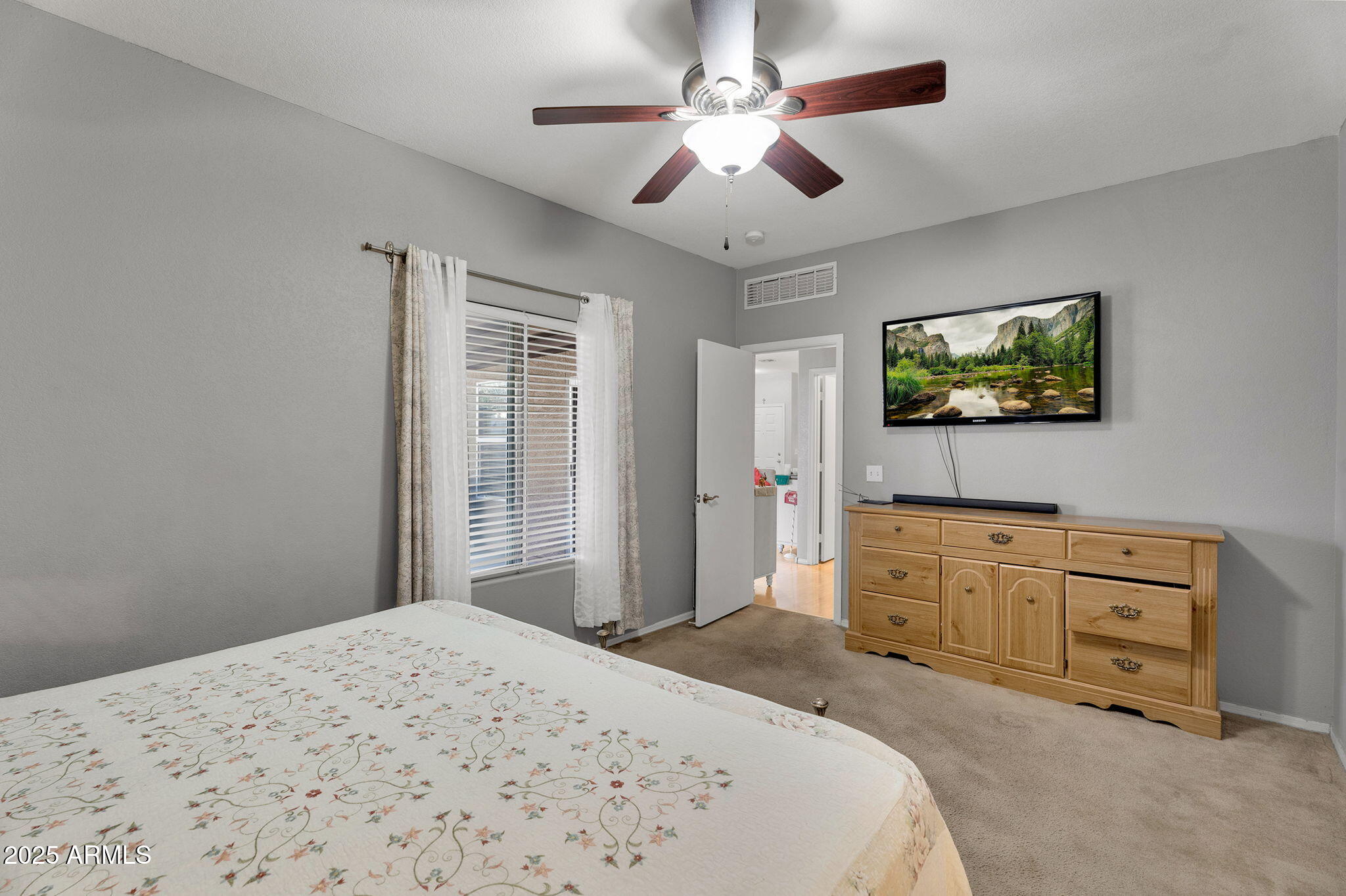 13122 West Calavar Road Surprise, AZ 85379 - Photo 15 of 34 a bedroom with a bed dresser and flat screen tv