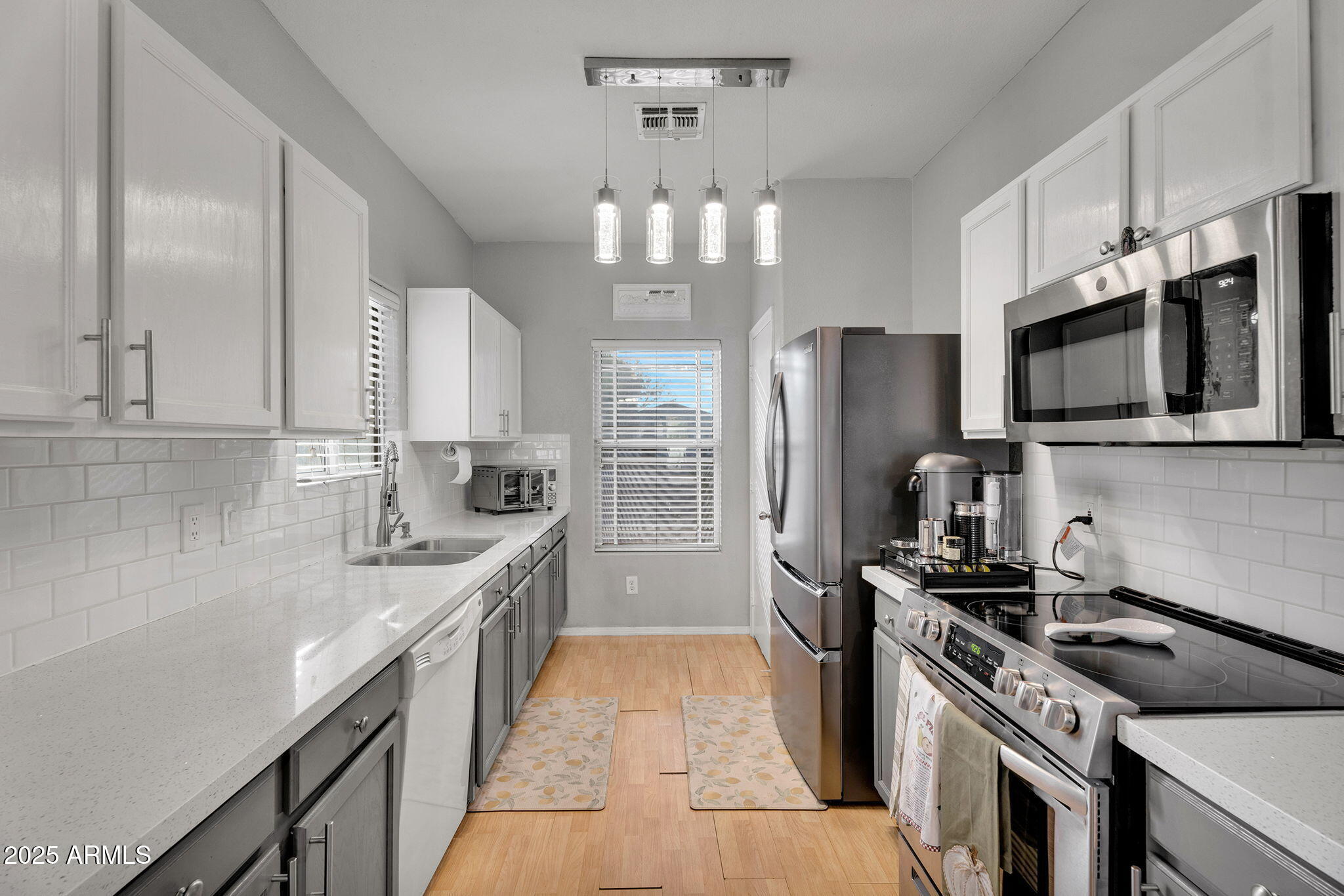13122 West Calavar Road Surprise, AZ 85379 - Photo 7 of 34 a kitchen with stainless steel appliances a sink stove microwave and refrigerator