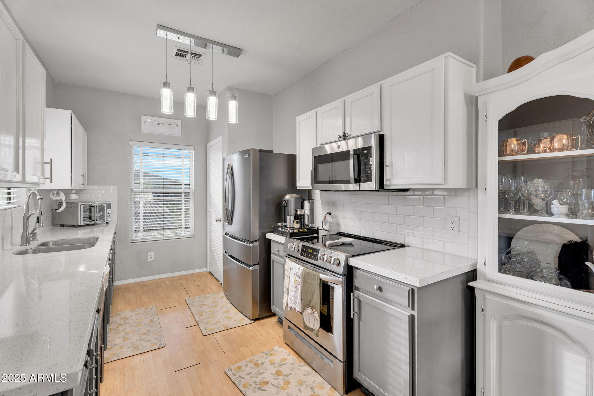 13122 West Calavar Road Surprise, AZ 85379 - Photo 9 of 34 a kitchen with a sink stove and refrigerator