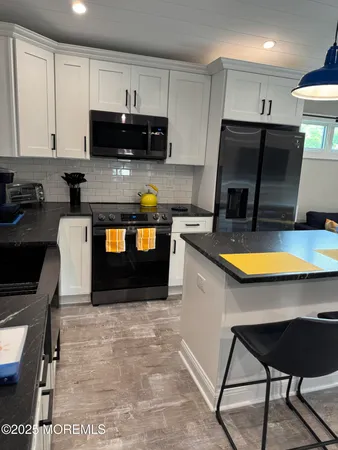 a kitchen with stainless steel appliances a stove a sink a microwave a refrigerator and cabinets