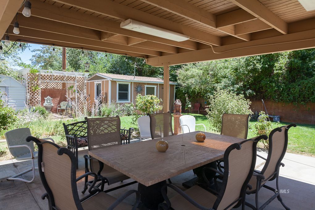 110 North Hay Street Lone Pine, CA 93545 - Photo 20 of 23 a view of a patio with table and chairs under an umbrella with a small yard