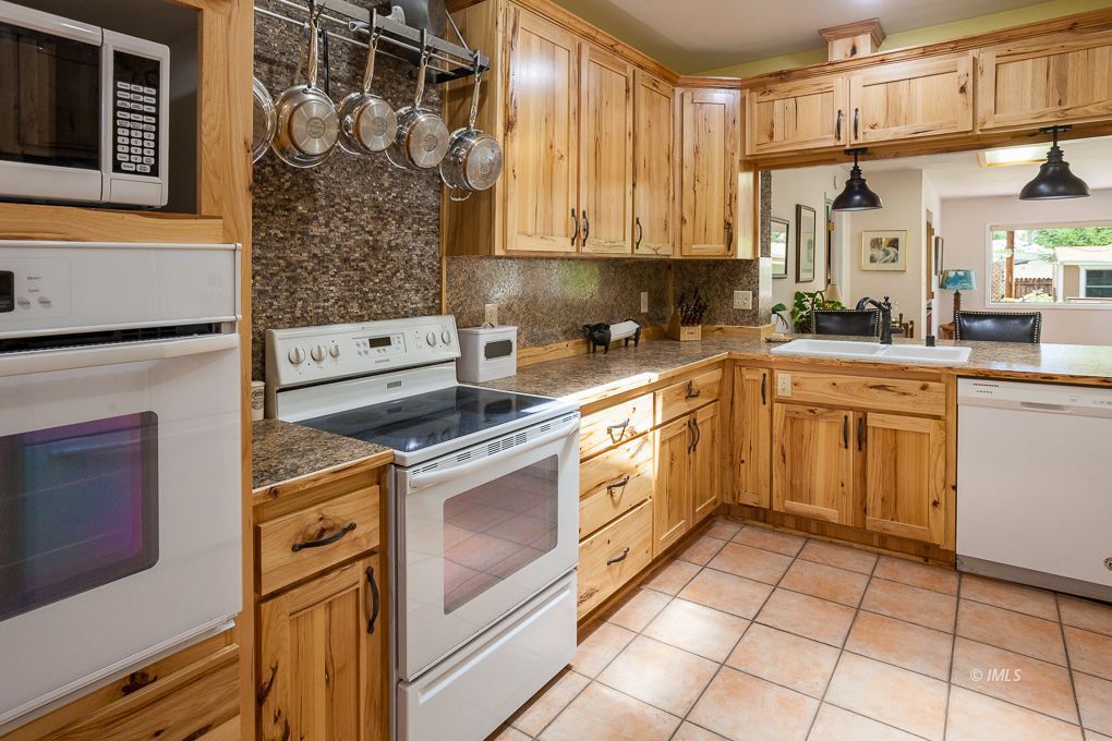 110 North Hay Street Lone Pine, CA 93545 - Photo 6 of 23 a kitchen with stainless steel appliances granite countertop a stove a sink and a microwave