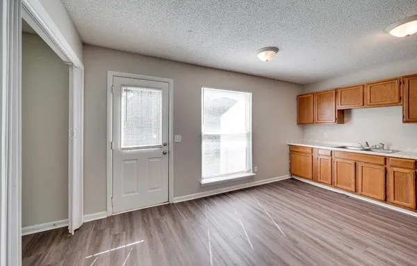 a view of a kitchen with wooden floor and a sink