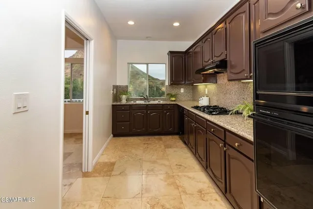 a kitchen with stainless steel appliances granite countertop a refrigerator and a sink