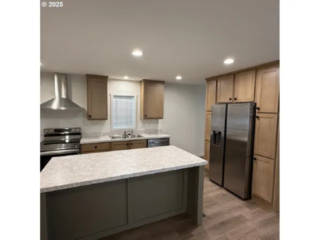 a kitchen with granite countertop a refrigerator and a sink