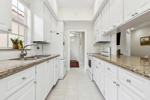 a large white kitchen with stainless steel appliances and counter space
