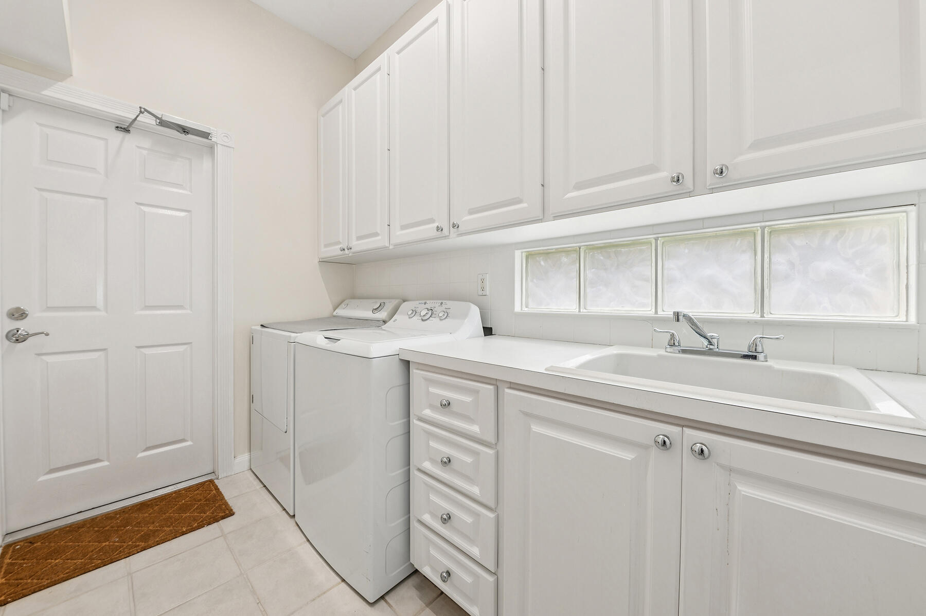 2613 James River Road West Palm Beach, FL 33411 - Photo 18 of 57 a kitchen with white cabinets and sink