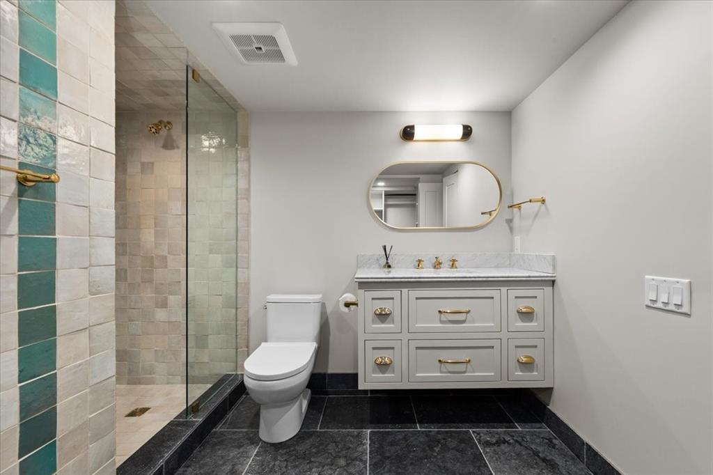 4259 Crestline Road Fort Worth, TX 76107 - Photo 22 of 40 a bathroom with a toilet a sink and a mirror