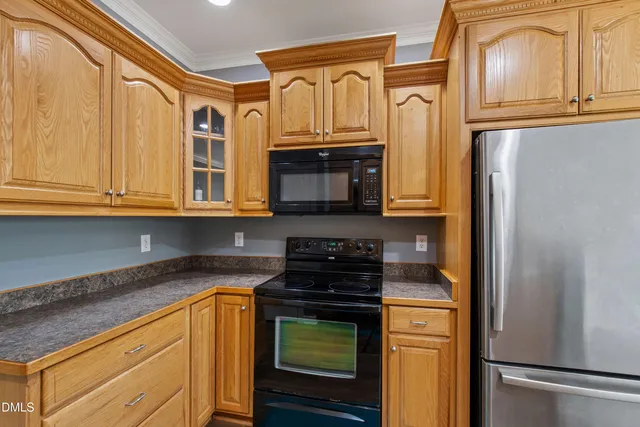 a kitchen with stainless steel appliances granite countertop a refrigerator and a stove top oven
