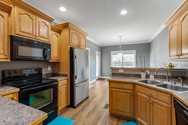 a kitchen with stainless steel appliances granite countertop a stove a sink dishwasher a refrigerator and cabinets with wooden floor