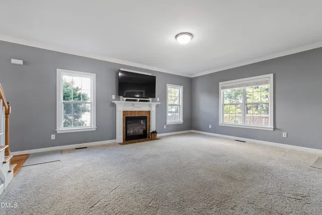 a view of an empty room with a window and a fireplace