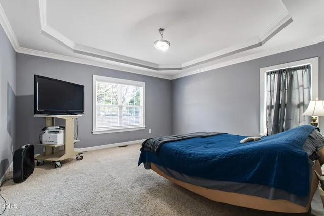 a bedroom with a bed and a flat tv screen on wall