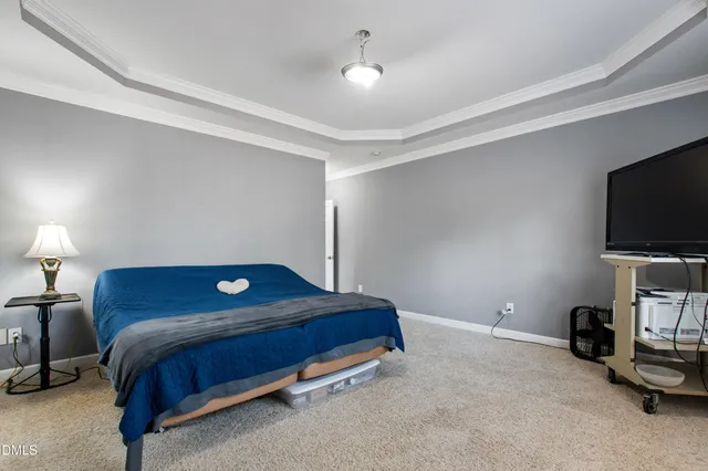 a bedroom with a bed and a flat tv screen on the dresser