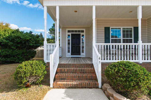 a view of a house with a large window and flower plants