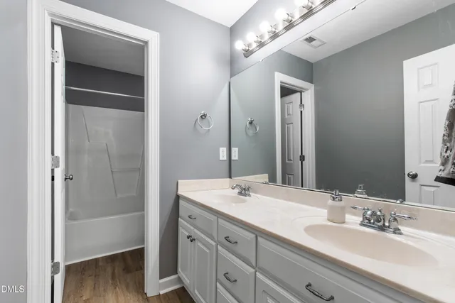 a bathroom with a double vanity sink mirror and shower
