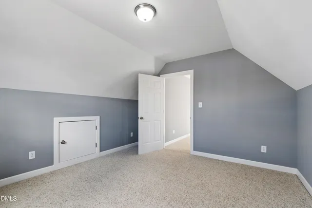 an empty room with closet and windows