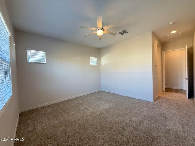 an empty room with closet and a chandelier fan