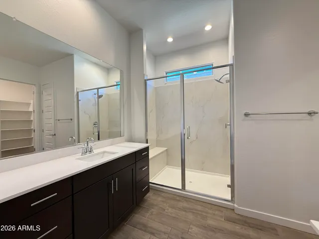 a bathroom with a double vanity sink mirror and shower