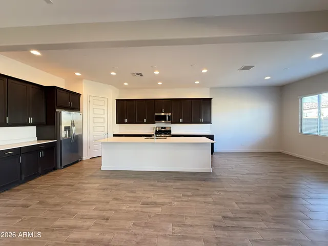 a large kitchen with stainless steel appliances kitchen island a large counter top a stove and a sink