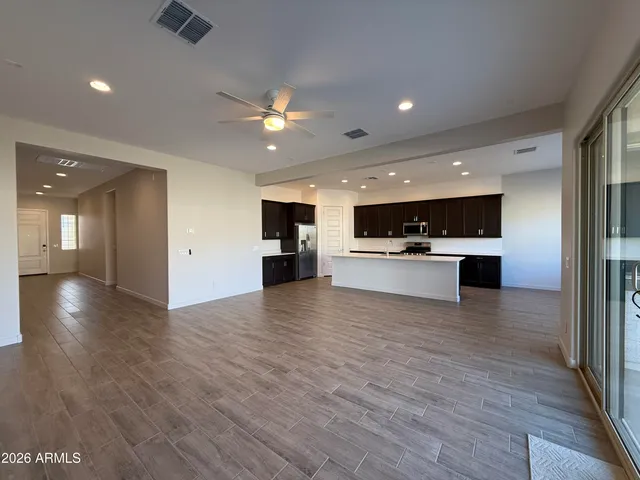 a view of kitchen with kitchen island a sink wooden floor and stainless steel appliances