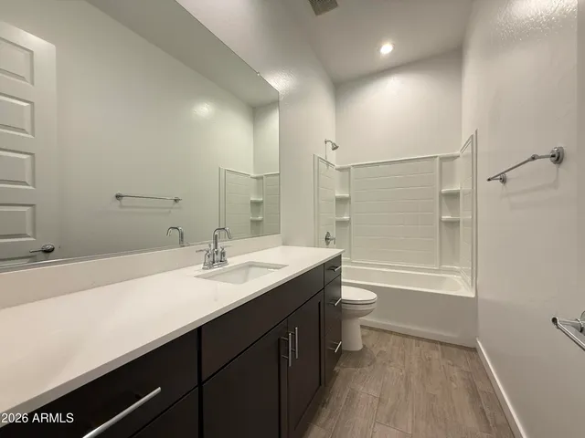 a bathroom with a sink a toilet and a large mirror