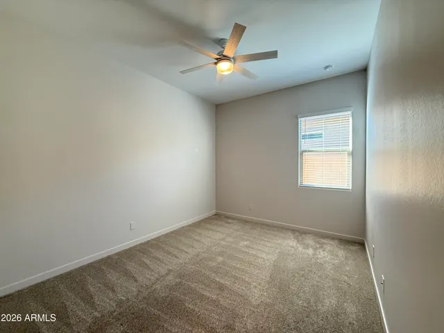 an empty room with closet and fan