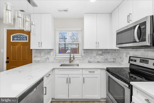 a kitchen with kitchen island a counter top space appliances and cabinets