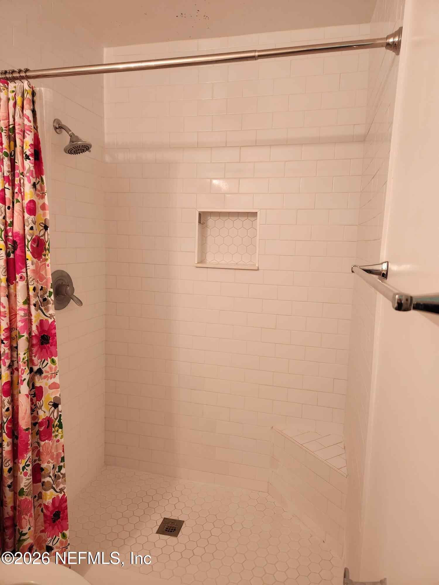 7915 Fresca Street Jacksonville, FL 32217 - Photo 12 of 20 a bathroom with a shower and a shower curtain