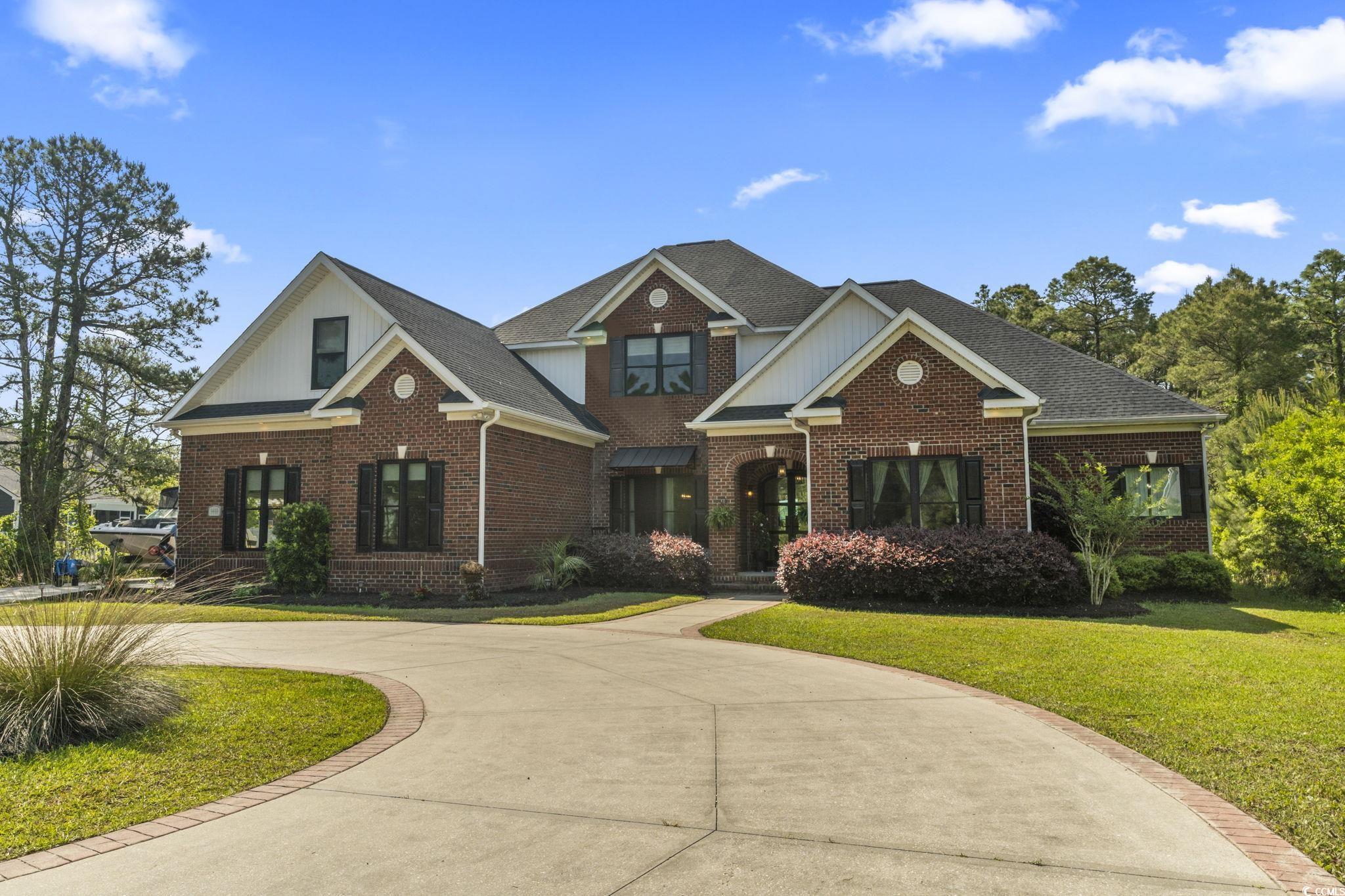 9449 Freewoods Road Myrtle Beach, SC 29588 - Photo 1 of 39 Craftsman-style house with curved driveway, brick siding, and a front yard