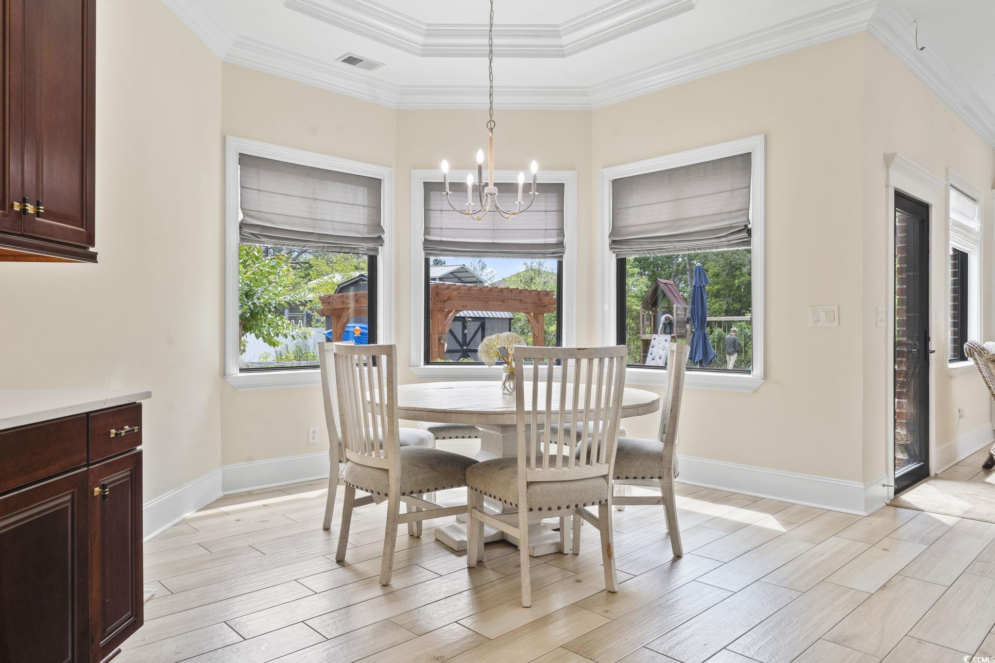 9449 Freewoods Road Myrtle Beach, SC 29588 - Photo 11 of 39 Dining space with a chandelier, light wood-style floors, baseboards, and ornamental molding