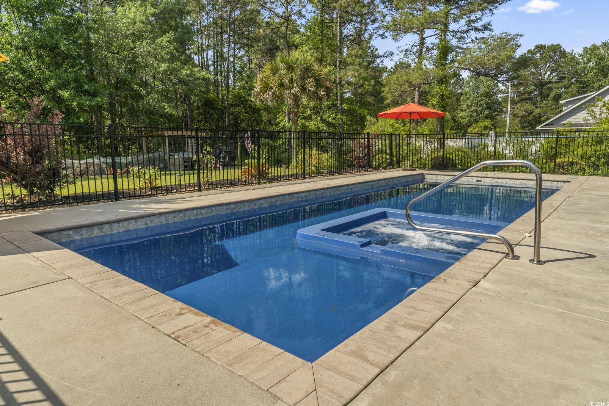 9449 Freewoods Road Myrtle Beach, SC 29588 - Photo 33 of 39 View of pool featuring a patio area, fence, and a pool with connected hot tub