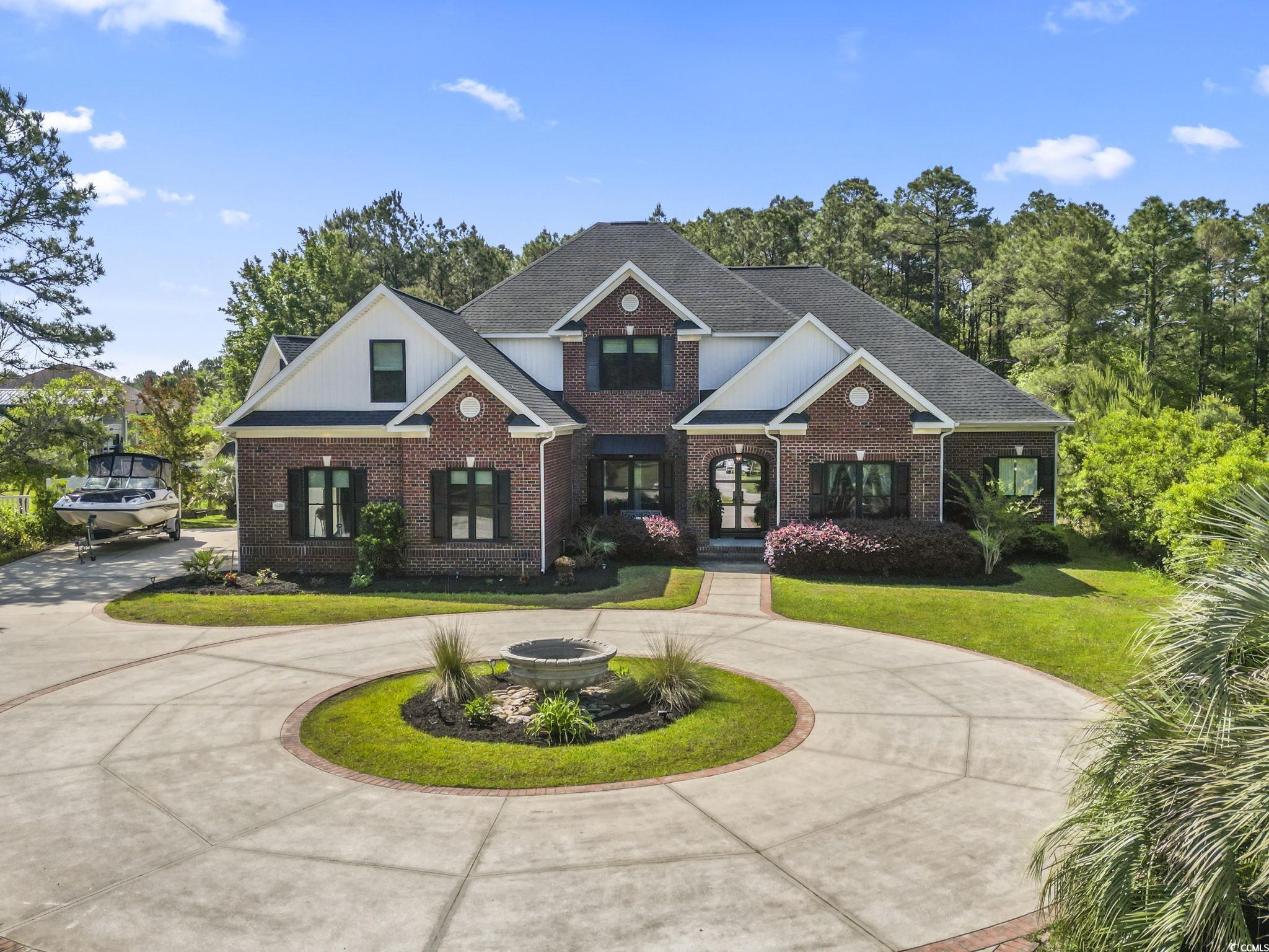 9449 Freewoods Road Myrtle Beach, SC 29588 - Photo 38 of 39 View of front of property with curved driveway, a front lawn, french doors, and brick siding