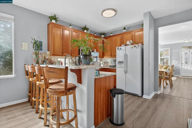 a kitchen with stainless steel appliances a refrigerator a table and chairs
