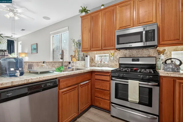 a kitchen with granite countertop a stove top oven microwave and cabinets