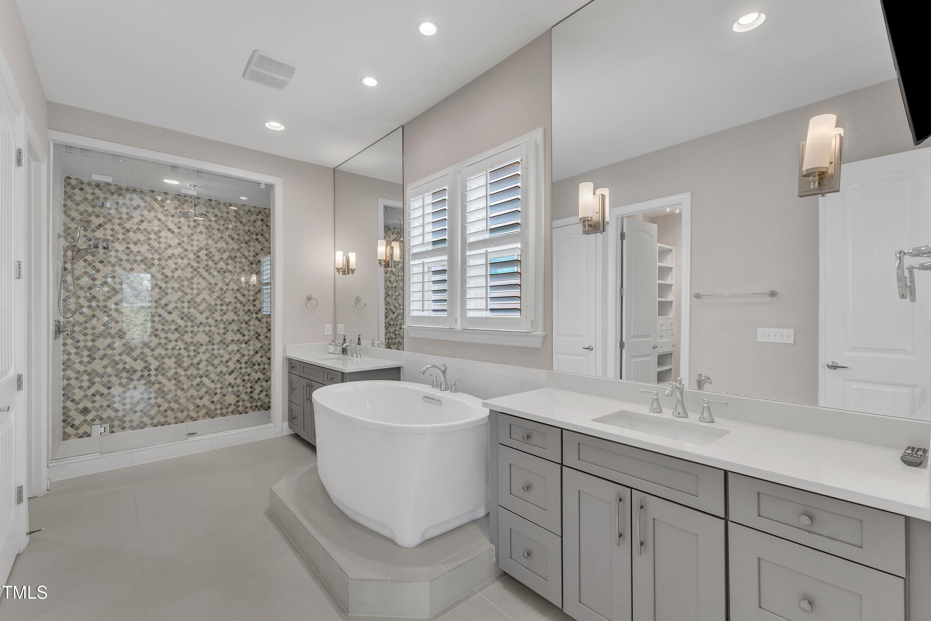 8121 Greys Landing Way Raleigh, NC 27615 - Photo 33 of 95 a spacious bathroom with double vanity sink a mirror a bathtub and shower