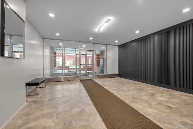 a large hall with stainless steel appliances kitchen island granite countertop furniture and a large window